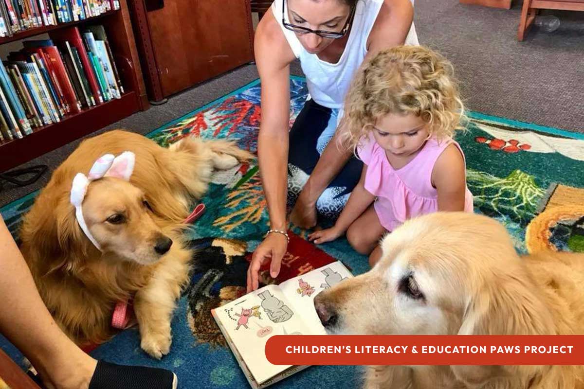Golden PAWS Assistance Dogs reading with small child and mother | CLEPP Children's Literacy and Education PAWS Project